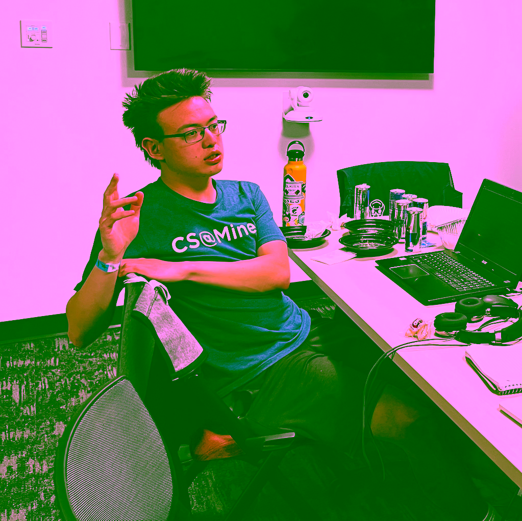 I lean back in my chair with one hand in the air. I am surrounded by many cans of Red Bull and empty plastic food containers.